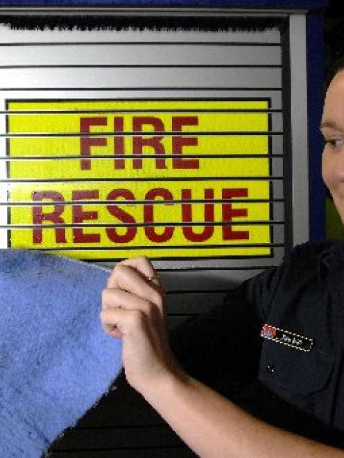 Fire Officer Emma Baird, of Dunedin, displays the remains of an electric blanket after a fire....
