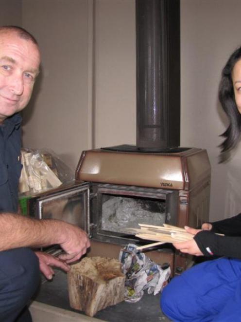 Fire safety officer Stuart Ide shows Enxin Chin, from Singapore, how to properly light a fire in...