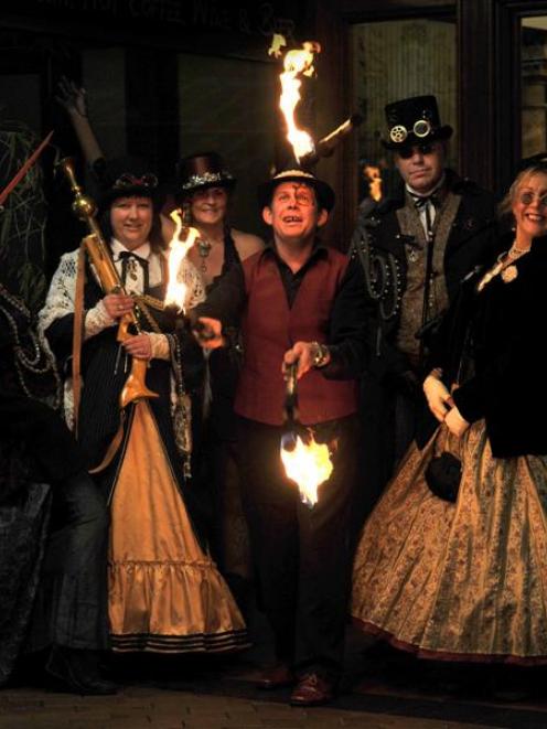 Fire-stick juggler James East welcomes steampunk ball-goers (from left) Fiona Rutland, from...