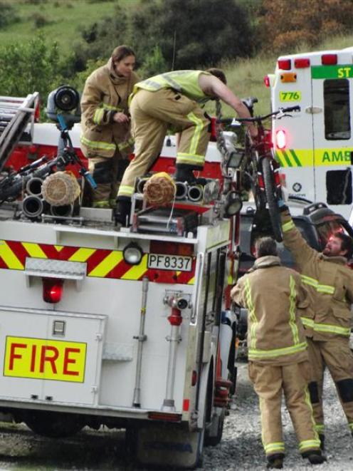 Fire volunteers take care of mountain bikes after a crash on Moke Lake Rd, near Queenstown, left...