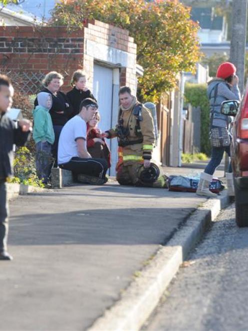 Firefighter Kerry McNamara talks to a woman from a house fire in Beresford St. Photo by Craig Baxter