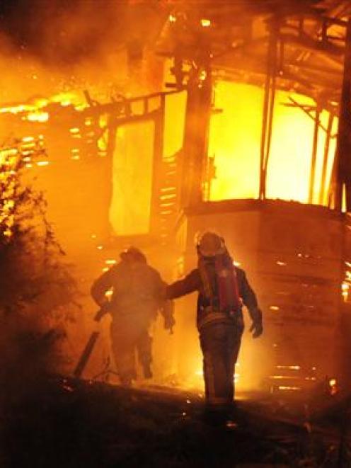 Firefighters battle a large house fire in Pine Hill Rd on Saturday night. Photo by Craig Baxter.