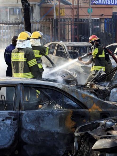 Firefighters douse cars after a bomb blast at a crowded shopping district in Abuja. REUTERS...