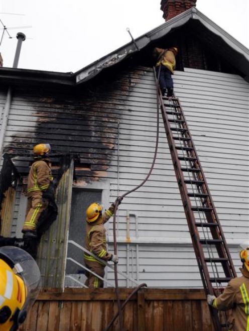 Firefighters  from Dunedin Central and Willowbank extinguish the fire yesterday. Photos by...