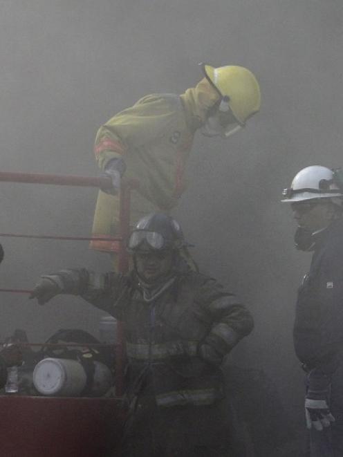 Firefighters stand amidst smoke coming out from a building housing a casino after an attack that...