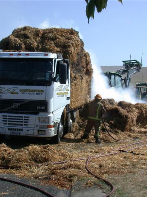 Firefighters try to put out a fire in straw on the back of a truck in Airedale Rd, Weston,...