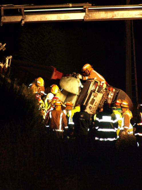 Firefighters work to free a man from an overturned truck at Branxholme  last  evening. Photo:...