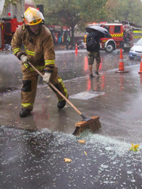 Firemen sweep up the mess at the Fiore on Auckland's Hobson St after a glass pane on the verandah...