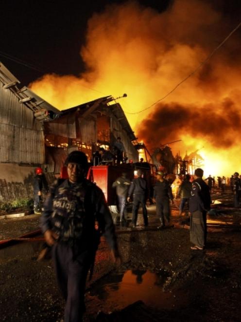 Firemen try to put out a blaze that killed 17 people and injured about 80 in Yangon, Myanmar this...