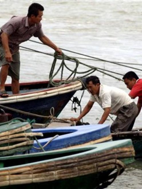 Fishermen work on their boats, preparing for Typhoon Conson, in Wanning, Hainan province, China....