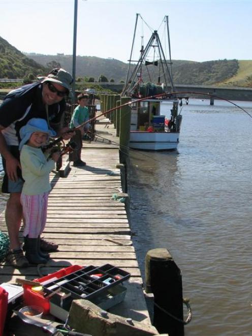 Fishing from the wharf at Taieri Mouth. On today's ride, you will pass the wharf before crossing...