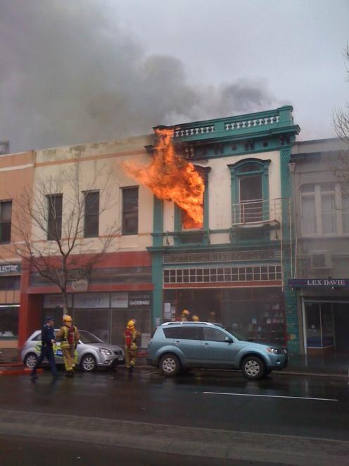 Flames shoot out of the building at 2.30pm. Photo by Craig Baxter
