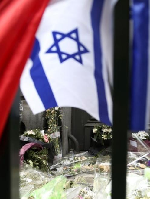 Flowers are seen near an Israeli flag at the entrance of the Jewish Museum in Brussels. REUTERS...
