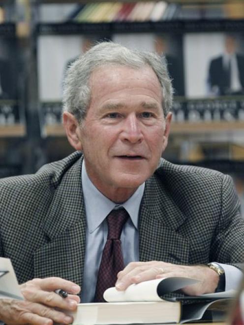 Former President George W. Bush signs a copy of his book 'Decision Points' at a store near his...