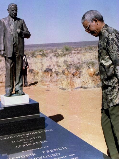 Former President Nelson Mandela and Orania Movement founder Carel Boshoff (R) inspect a statue of...