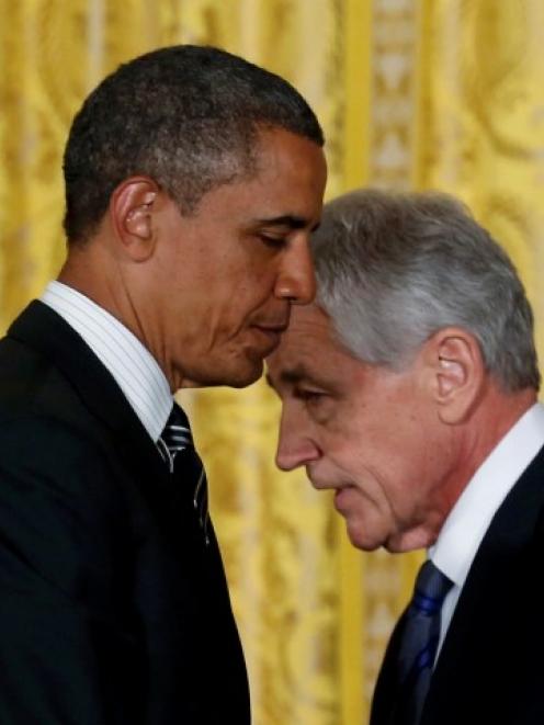 Former US senator Chuck Hagel (R) walks past US President Barack Obama after Obama announced the...