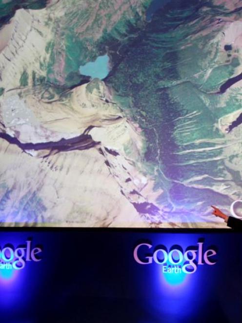 Former Vice President Al Gore points at a screen showing the new Google Earth 5.0 at the...