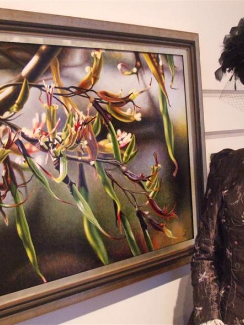 Forrester Gallery curator Else Mackenzie admires a painting of flax flowers by Barry Walsh. Photo...