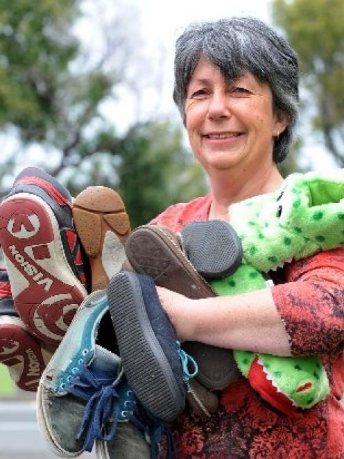 Foster carer Helen Reynolds holds shoes from her current family of five children. Photo by...