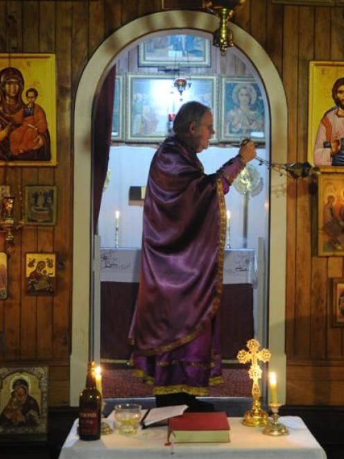 Fr Carl Somers-Edgar swings an incense burner inside St Michael's Greek Orthodox Church of...