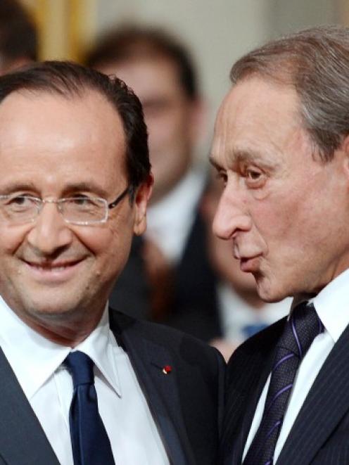 France's new President Francois Hollande (L) speaks with Paris mayor Bertrand Delanoe during the...