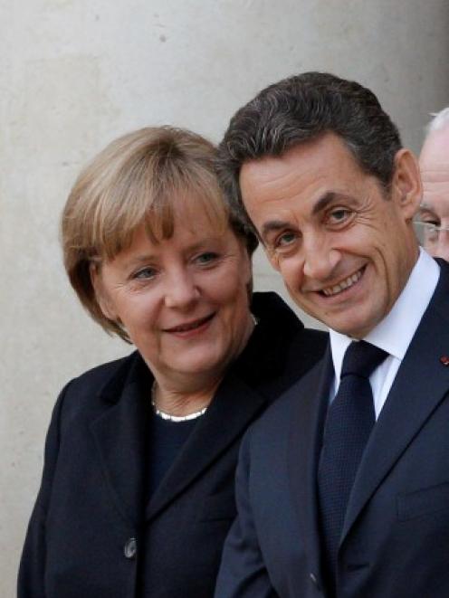 France's President Nicolas Sarkozy escorts German Chancellor Angela Merkel following a joint news...