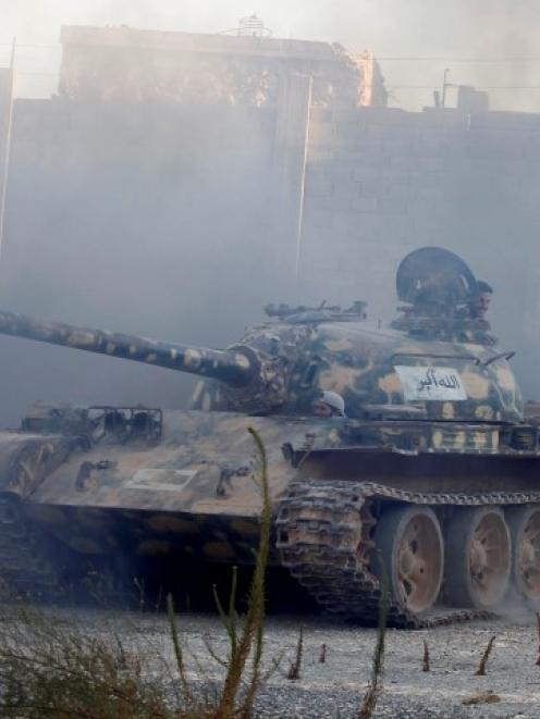 Free Syrian Army fighters drive a tank towards the front line in Aleppo's Sheikh Saeed...