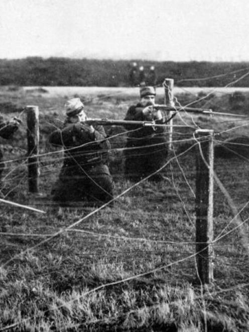 French soldiers firing through wire entanglements. – Otago Witness, 7.4.1915. Copies of picture...