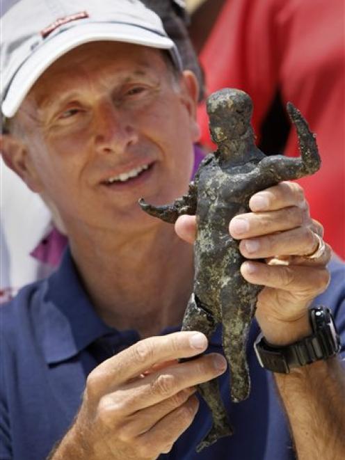 French underwater archaeologist Franck Goddio shows a recently excavated bronze cult statue found...