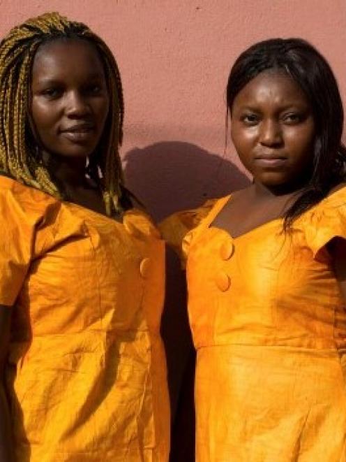 Friends Nhama Mane (L) and Suncar Darame pose in matching outfits in the Mistra district of...