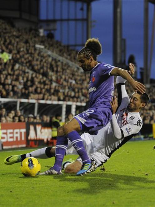 Fulham's Clint Dempsey, below, tackles Tottenham Hotspur's' Benoit Assou-Ekotto during their...