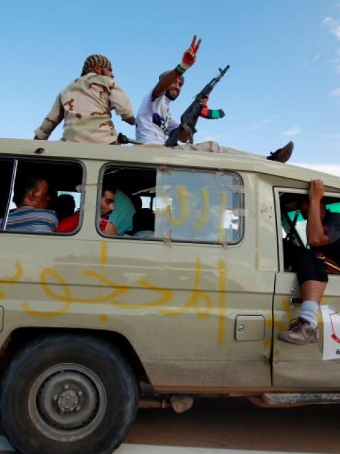 Gaddafi loyalists are captured by anti-Gaddafi fighters in a vehicle, in the centre of Sirte,...