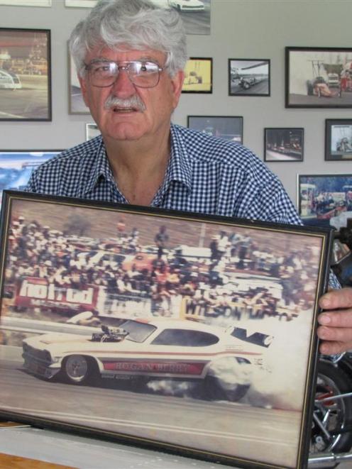 Garth Hogan, of Wanaka, with a photograph of the ''funny car'' he broke the 200mph (320kmh)...