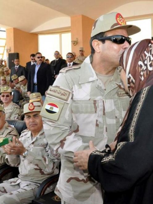 General Abdel Fattah al-Sisi kisses the mother of an army officer who was killed during the...