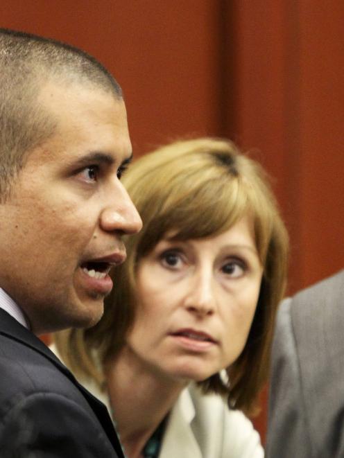 George Zimmerman talks to his lawyer Mark O'Mara and O'Mara's legal associate Lorna Truett at the...