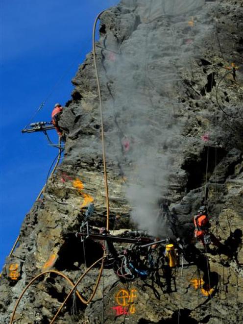 Geovert  workers yesterday drill into the Zeus Column on the Nevis Bluff,  about 170m above State...