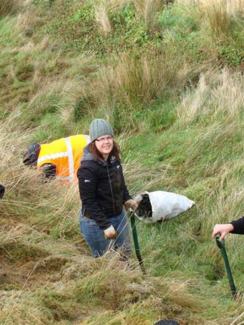 Gerald Scoones (left) and Debs McKinstry (both of Gen-i) and Mark Ascroft (Telecom) plant trees...