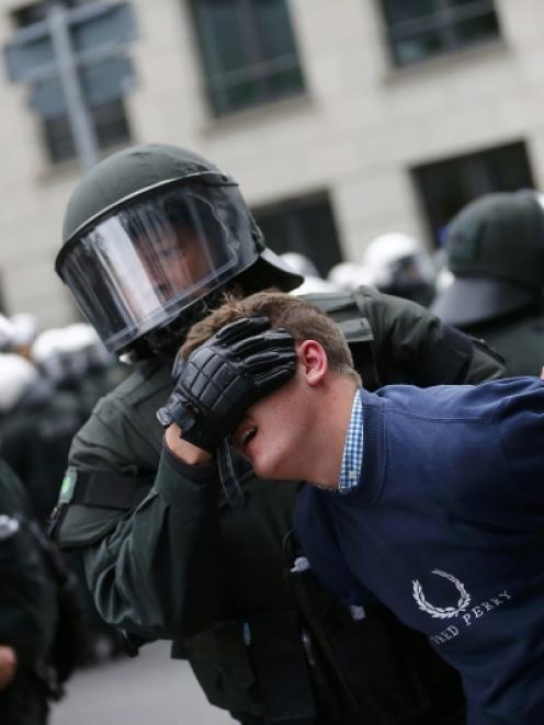 German riot police detain protester during an anti-capitalism "Blockupy" demonstration in...