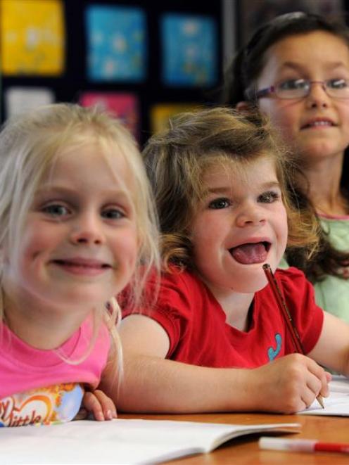 Grace Hughes (centre) completes a task  with her classmates Renee Grimstrup (5, left) and...