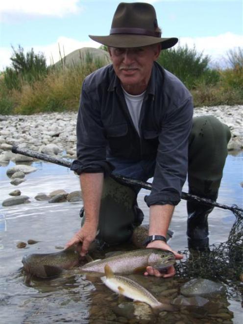 Fish and Game officer Gareth Hughes holds trout caught in the Hakataramea River which will be...