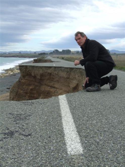 Graeme Clark views the effect of coastal erosion on a closed section of Beach Rd in 2010. Photo...