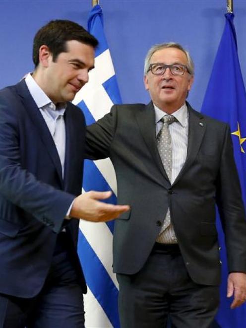 Greek Prime Minister Alexis Tsipras (left) is welcomed by European Commission President Jean...