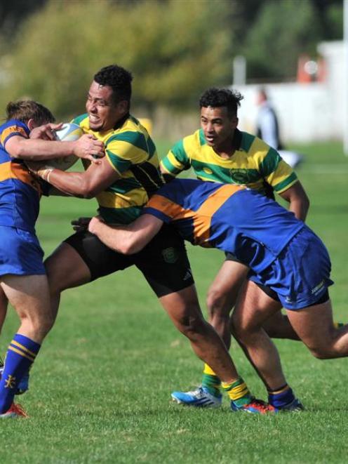 Green Island centre Tino Elisara tries to smash through the tackle of Taieri first five eighth...