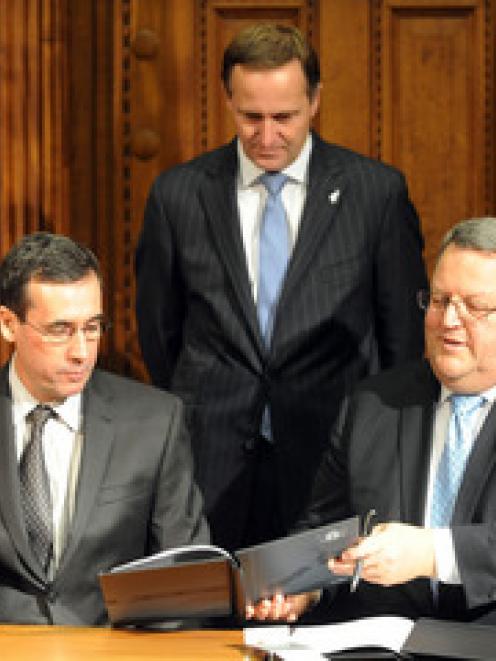 Minister of Energy and Resources Gerry Brownlee, right signs an agreement with Marcelo Carlos...