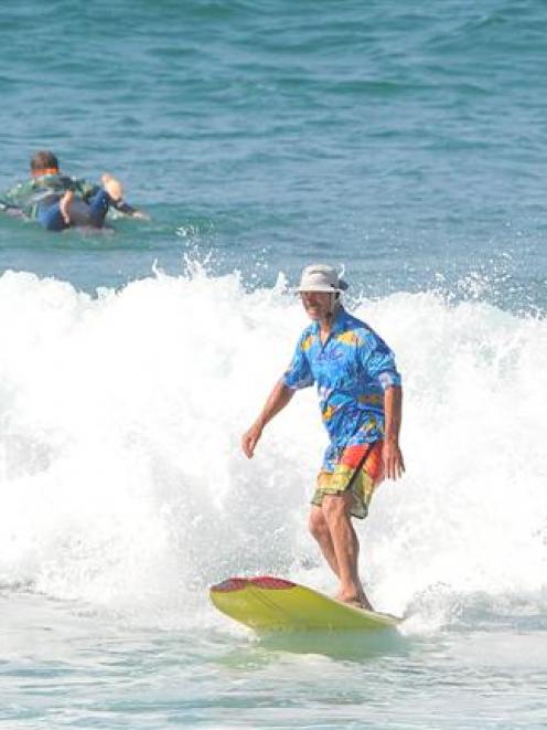 Greg Page, of Dunedin, sports his Hawaiian shirt while riding a long board at St Clair Beach...