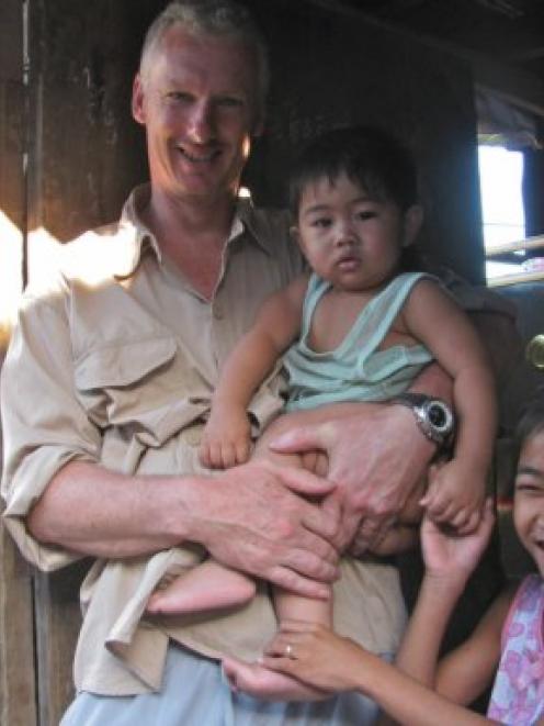 Hands full ... Aid volunteer Alistair Craig with two members of a Cambodian family, Boo and...