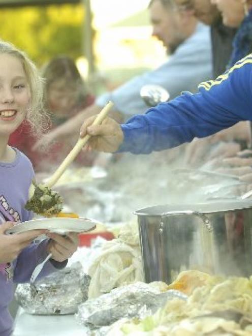 Forbury School (Dunedin) pupil Barbie Taylor (10) is served vegetables and meat by school...