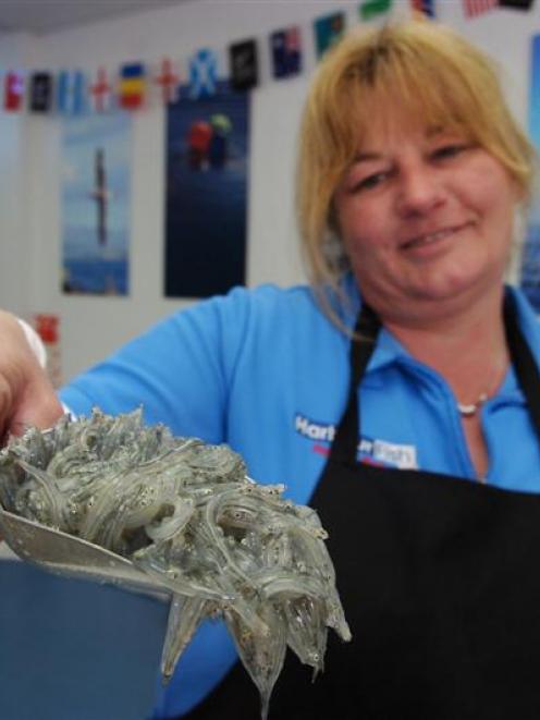 Harbour Fish store manager Nancy Anderson with a scoop of West Coast whitebait. Photo by Jane...
