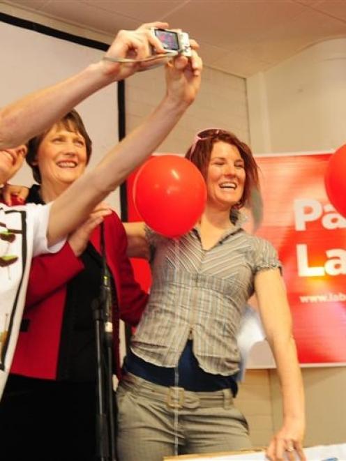 Helen Clark poses for a photograph with two students at the University of Otago common room...