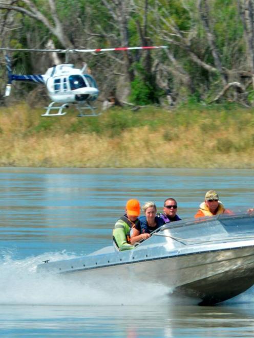Helicopter and jet-boat-borne search parties head out on the Clutha River yesterday looking for...